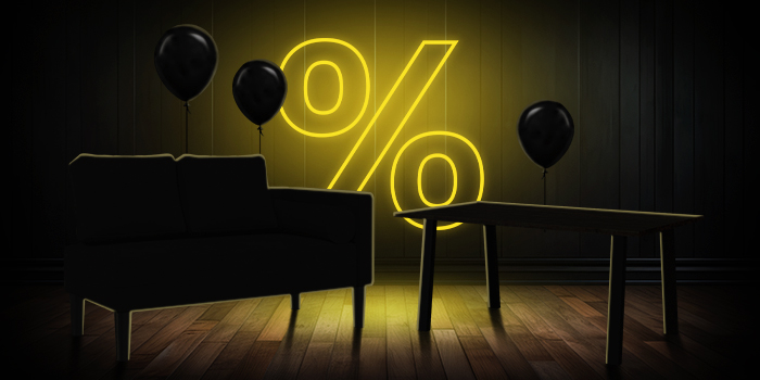 Черна мека мебел и дървена маса с черни балони пред светещ жълт знак за процент върху тъмен дървен под.