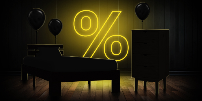 Черно легло и скрин с черни балони пред светещ жълт знак за процент върху тъмен дървен под.